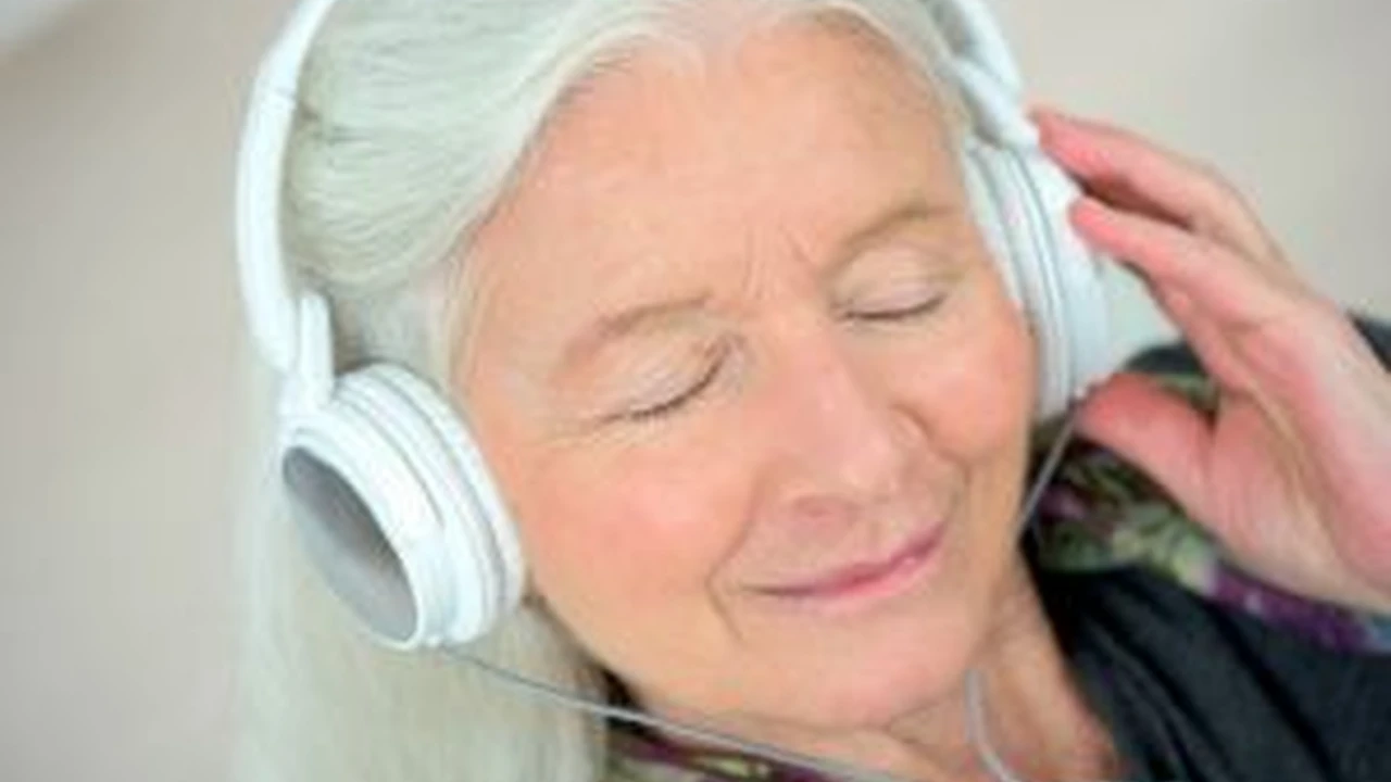 Close up on a plate of mashed potatoes, topped with baked pork chops with cream of mushroom soup, and a side of green beans.