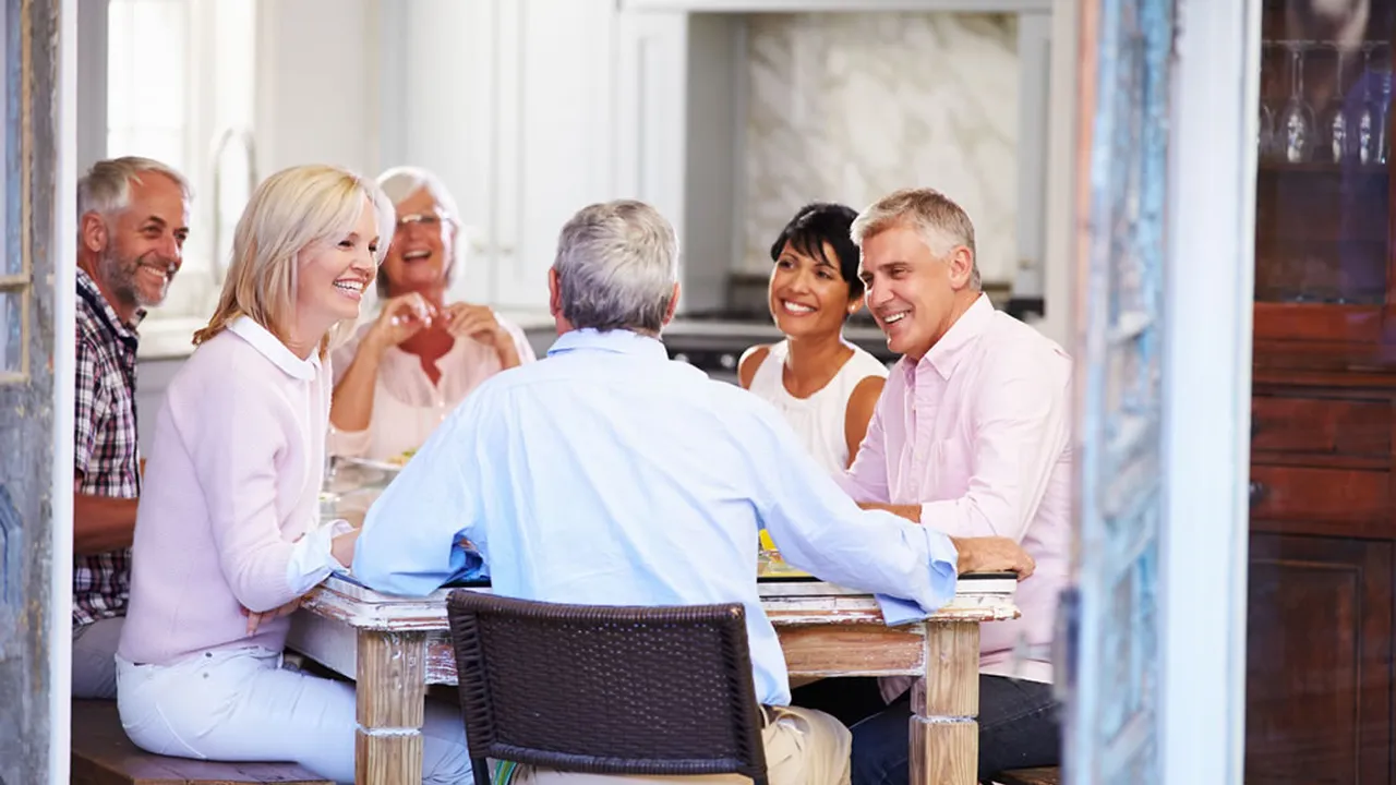 Close up on a plate of mashed potatoes, topped with baked pork chops with cream of mushroom soup, and a side of green beans.