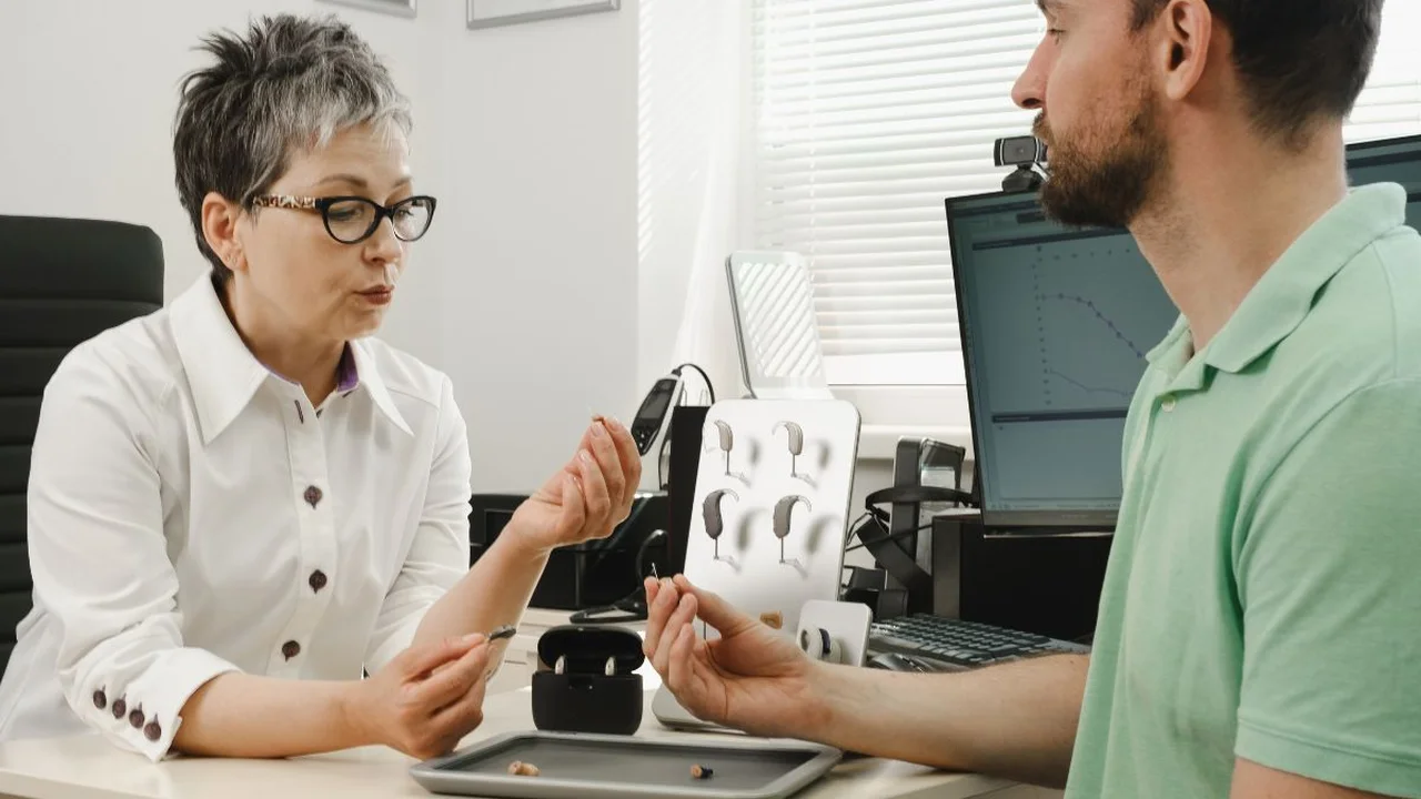 Close up on a plate of mashed potatoes, topped with baked pork chops with cream of mushroom soup, and a side of green beans.