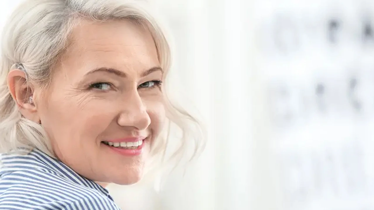 Close up on a plate of mashed potatoes, topped with baked pork chops with cream of mushroom soup, and a side of green beans.