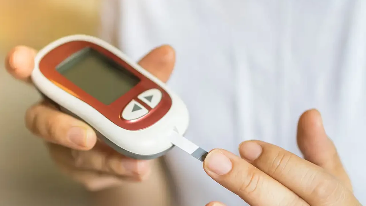 Close up on a plate of mashed potatoes, topped with baked pork chops with cream of mushroom soup, and a side of green beans.