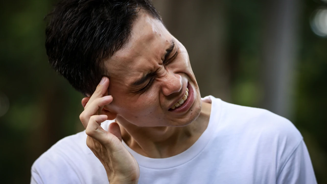 Close up on a plate of mashed potatoes, topped with baked pork chops with cream of mushroom soup, and a side of green beans.