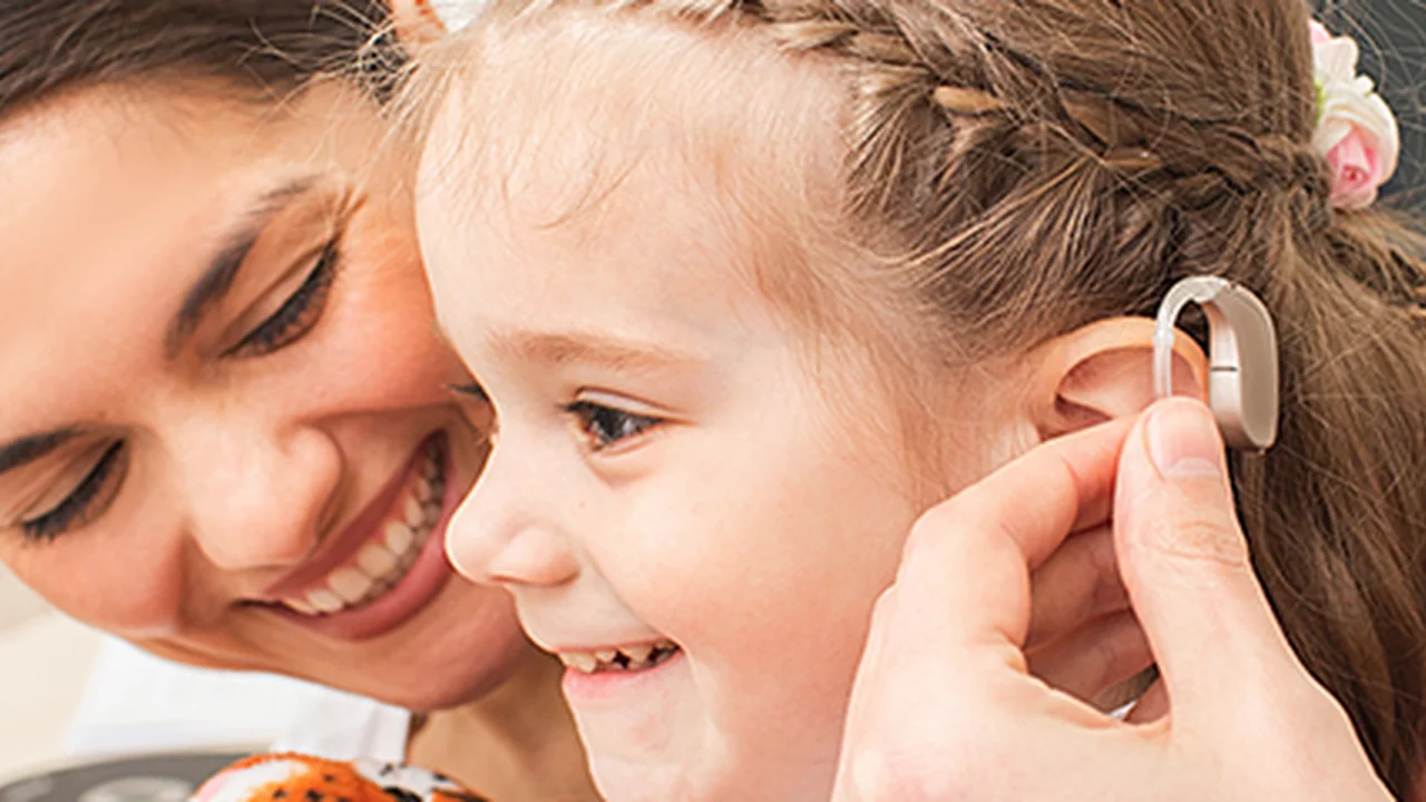Close up on a plate of mashed potatoes, topped with baked pork chops with cream of mushroom soup, and a side of green beans.